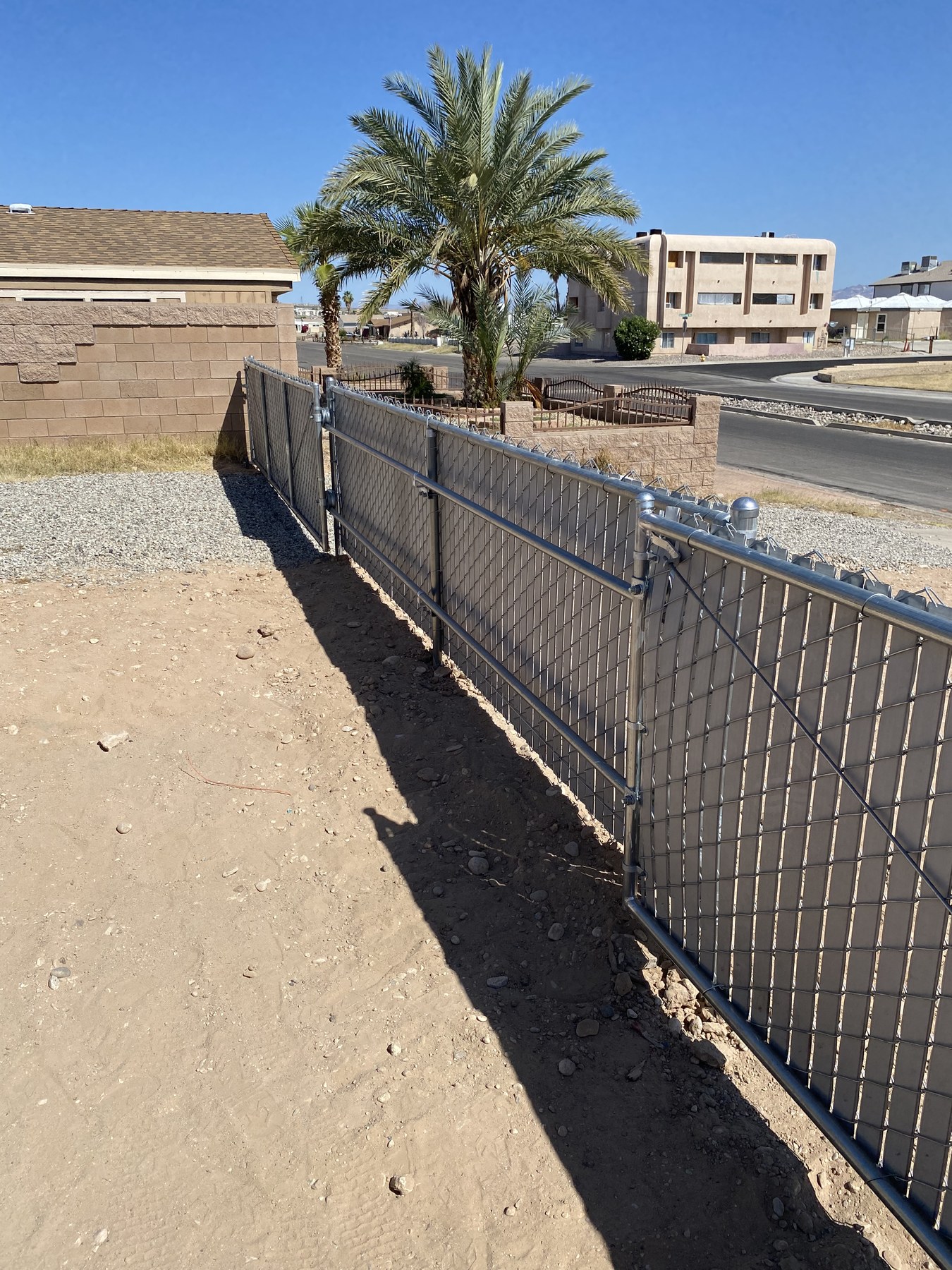 Completed privacy-slat chain-link fence installed by Tri-City Fence